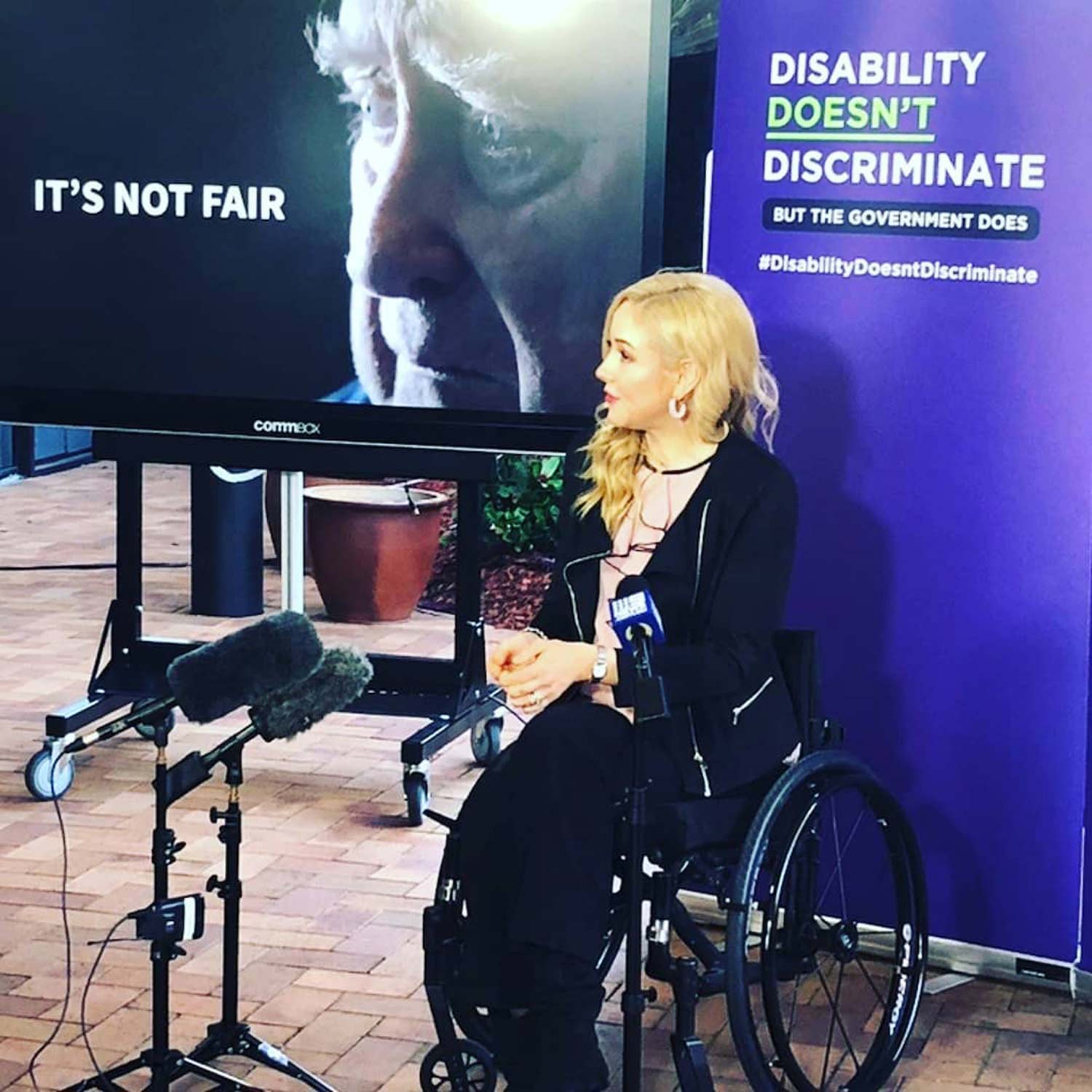 Lisa Cox on stage at discussing discrimination by government against PWD Lisa Cox on stage at discussing discrimination by government against PWD